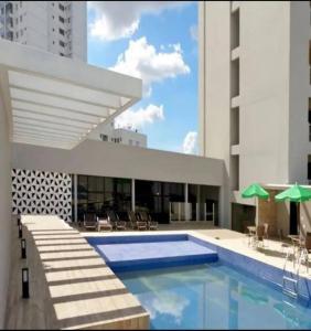 a swimming pool in front of a building at Flat confortável e econômico hotel condomínio cristal place in Goiânia
