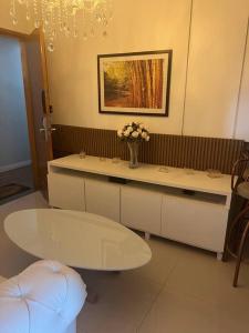 a bathroom with a vase of flowers on a counter at Flat confortável e econômico hotel condomínio cristal place in Goiânia