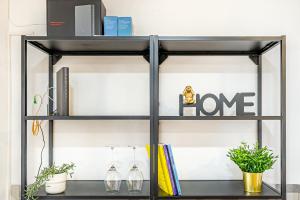 a black shelf with books and plants on it at Sintra Nest - Near the train to Lisbon and Sintra (3 min) in Sintra