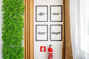 eine grüne Wand mit vier Bilderrahmen und einem Hydranten in der Unterkunft Sintra Nest & Loft by Lisbon with Sintra in Sintra