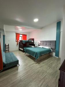 duży pokój z 2 łóżkami i kanapą w obiekcie Hospedaje Vacacional y Familiar Baños w Baños