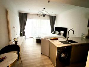 een slaapkamer met een bed en een keuken met een tafel bij Brand new Modern Studio High Floor near Burj in Dubai
