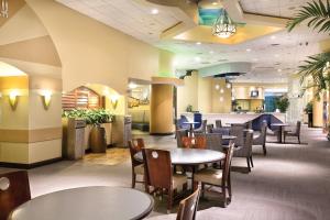 un restaurante con mesas y sillas y un bar en Club Wyndham Ocean Walk, en Daytona Beach