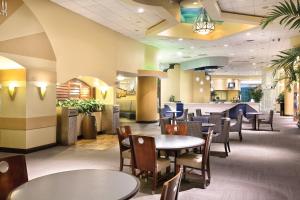 a restaurant with tables and chairs and a bar at Club Wyndham Ocean Walk in Daytona Beach
