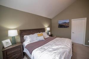 1 dormitorio con 1 cama grande con 2 lámparas y puerta en Juneau Oceanfront Home Overlooking Auke Bay, en Mendenhaven