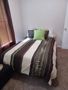 a bed with a green pillow on top of it at Urban Adventure Townhome - Near Downtown Atlanta in Atlanta