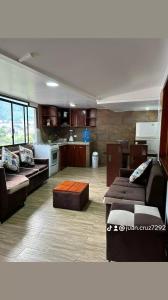 sala de estar amplia con sofás y cocina en Hospedaje Vacacional y Familiar Baños, en Baños