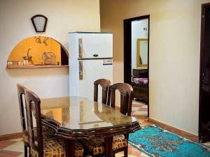 ein Esszimmer mit einem Glastisch und einem Kühlschrank in der Unterkunft Ramses Downtown Apartment in Luxor