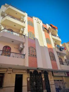 ein hohes Gebäude mit Balkon an der Seite in der Unterkunft Ramses Downtown Apartment in Luxor