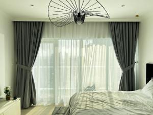 a bedroom with a bed and a large window at Brand new Modern Studio High Floor near Burj in Dubai