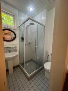 a bathroom with a shower and a toilet and a sink at Pousada Canto Verde in Tiradentes