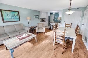 a living room with a couch and a table and chairs at Astonishing 2 Bdm King Resort View Villa 2nd Flr in Pawleys Island