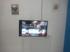 einen Flachbild-TV, der an einer weißen Wand hängt in der Unterkunft Espaço Só Alegria em Parnamirim-RN in Parnamirim