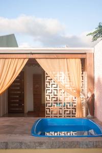 a pool in front of a house with curtains at Magic house banheira de hidromassagem e piscina in Rio Grande