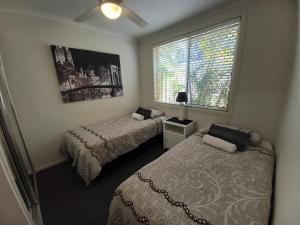 um quarto com 2 camas e uma janela em Oceana Holiday Units em Coffs Harbour