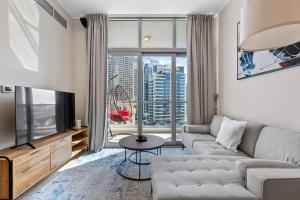 a living room with a couch and a television at Luxe Living: Dec Marina Haven_1br in Dubai Marina in Dubai
