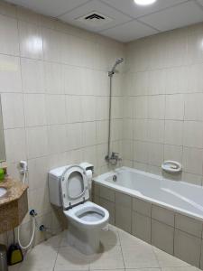 a bathroom with a toilet and a bath tub at FT22 R3 Open beach ajman washroom is outside in Ajman 