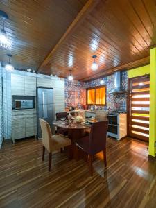 eine Küche mit einem Tisch und Stühlen im Zimmer in der Unterkunft Magic house banheira de hidromassagem e piscina in Rio Grande