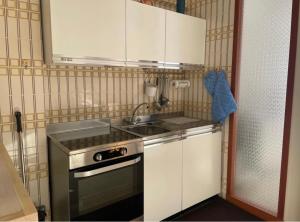 Una pequeña cocina con fregadero y estufa. en CASA VACANZA NIDO COLLETTO, en Case Arfel 22 fotos más