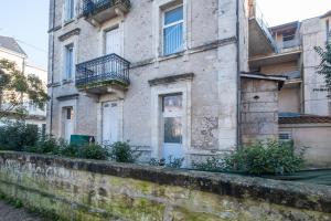 un antiguo edificio de piedra con balcón en una calle en Le St Martin en Périgueux