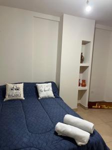 - une chambre avec un lit bleu et des serviettes dans l'établissement DEPARTAMENTO CENTRO SAN SALVADOR DE JUJUY, à San Salvador de Jujuy