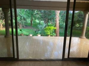 uma porta de vidro aberta para um pátio com vasos de plantas em The ranch apartments, en-suite rooms em Lusaka