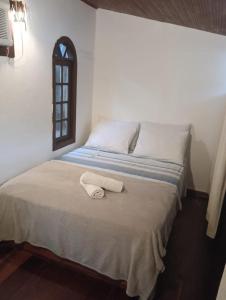 ein Schlafzimmer mit einem Bett und einem Handtuch darauf in der Unterkunft Buganville Loft in Abraão