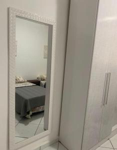 een spiegel voor een slaapkamer met een bed bij Cobertura Macaé in Macaé