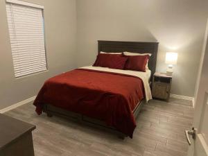 a bedroom with a bed with red sheets and a window at Spacious Getaway near UTRGV in Edinburg