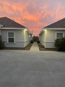 two white houses with a sunset in the background at Spacious Getaway near UTRGV in Edinburg
