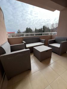 balcón con sillas y mesas de mimbre y ventana en Downtown Apartment, en Strumica