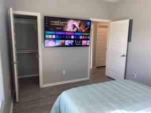 a bedroom with a flat screen tv on the wall at Spacious Getaway near UTRGV in Edinburg