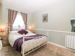 una camera con un letto bianco e una finestra di Ty Newydd Bach a Bangor