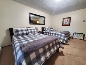 a bedroom with two beds and a mirror on the wall at Updated Duplex with Mountain & Filtered Water View in Juneau