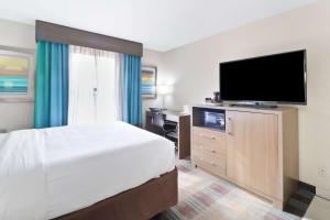 a bedroom with a bed and a flat screen tv at Comfort Inn Dunn near I-95 in Dunn