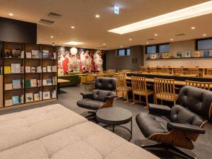 een bibliotheek met stoelen, een tafel en boeken bij Comfort Hotel ERA Kyoto Toji in Kyoto