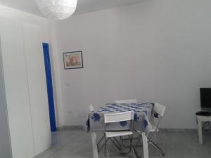 Cette chambre blanche dispose d'une table et d'une chaise. dans l'établissement Ferienwohnung im Erdgeschoss - b43981, à Leuca