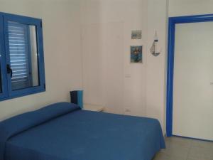 - une chambre avec un lit bleu et une fenêtre dans l'établissement Ferienwohnung im Erdgeschoss - b43981, à Leuca