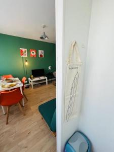 a living room with a table and a dining room at Le Vibrant Bubble - Studio Parking 10 min U-Arena La Défense in Houilles