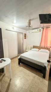 a bedroom with a bed and a table at HOTEL BOUTIQUE SONNE BALOP Valledupar in Valledupar