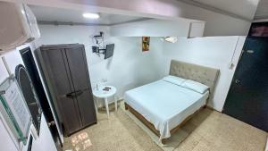 Habitación pequeña con cama y lavamanos en BOUTIQUE Hotel Balop, en Valledupar