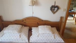 - 2 lits avec des oreillers blancs et un cœur sur le mur dans l'établissement Ferienhaus für 4 Personen ca 100 qm in Nova Vas nad Dragonjo, Küstenland Slowenien, à Nova Vas nad Dragonjo