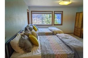 two twin beds in a room with a window at Breathtaking Ocean, Mountain & Juneau Views in Juneau