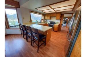 a kitchen with a large island with chairs in it at Breathtaking Ocean, Mountain & Juneau Views in Juneau