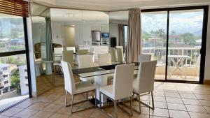 uma sala de jantar com uma mesa e cadeiras brancas em Entire 2 Bedroom Apartment w/ Ocean Views em Coolum Beach