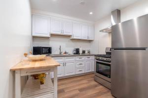 a kitchen with white cabinets and a stainless steel refrigerator at Acogedora Casa Cerca de Todo in Los Angeles