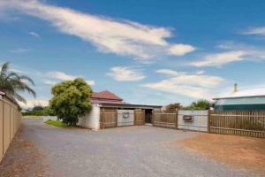 a house with a fence in front of a driveway at Charming 3 bedroom wine country cottage in Rutherglen