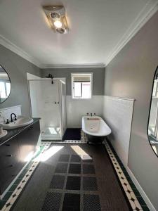 a bathroom with a sink and a shower and a toilet at Charming 3 bedroom wine country cottage in Rutherglen