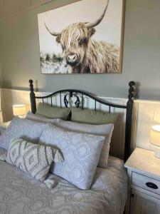 a bedroom with a bed with a picture of a bull at Charming 3 bedroom wine country cottage in Rutherglen