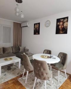 salon z białym stołem i krzesłami w obiekcie Apartman Tajna w mieście Sremčica
